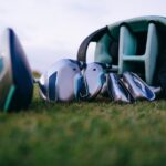 Set of golf clubs lies on a grass field, perfect for golfing enthusiasts.