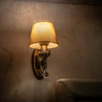 Vintage wall sconce casting a warm and cozy glow in an indoor setting, perfect for ambiance.