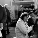 A candid street photo capturing urban life, showing people walking and interacting.