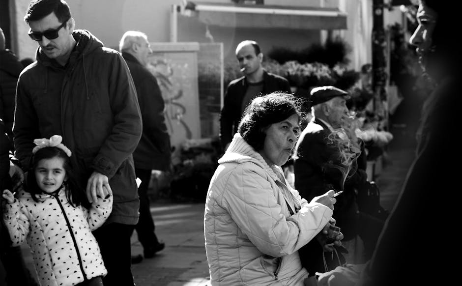 A candid street photo capturing urban life, showing people walking and interacting.