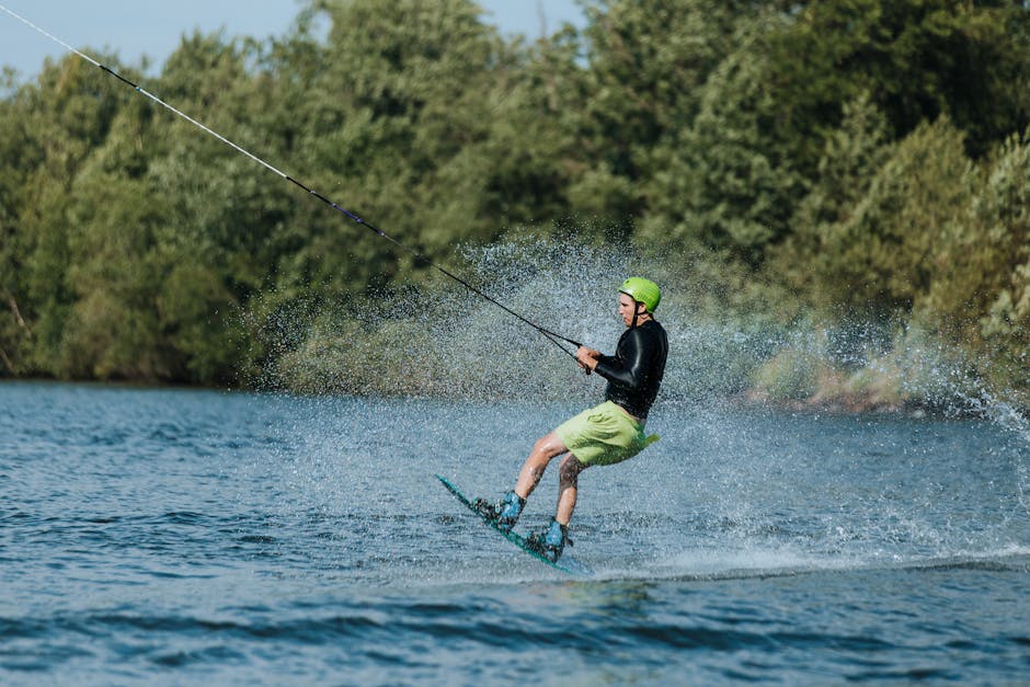 A man wakeboarding on a beautiful sunny day, creating splashes while gliding across a lake.