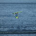 A thrilling moment of a person performing an aerial waterski trick on a sunny day.