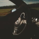Close-up of a car interior with a focus on the steering wheel and dashboard.