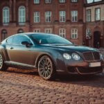 Elegant Bentley Continental GT on cobblestone street in historic Copenhagen during daytime.